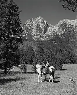 Grand Prints: Vintage photograph. View of two small children on horses in front of mountains at Grand Teton National Park