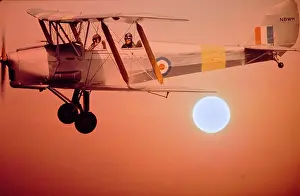 Aviator Prints: Vintage Photograph. Vintage biplane soars against a stunning sunset sky