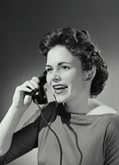 Medium Length Hair Prints: Vintage Photograph. Woman with curled hairstyle holding up telephone receiver having conversation