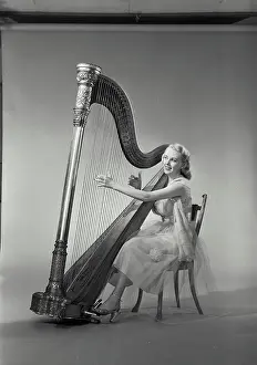 Williams Prints: Vintage Photograph. Woman in dress sitting in chair playing Grand Pedal Harp. Frame 8
