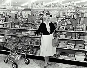 Variety Prints: Vintage Photograph. Woman excitedly shopping for homewares at the supermarket