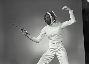Gear Prints: Vintage Photograph. Woman in fencing gear holding out saber in fighting stance. Frame 4