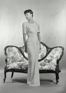 Settee Prints: Vintage photograph. Woman in full length dress standing in front of small settee couch