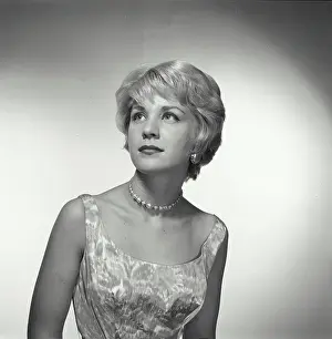 Vintage Photograph. Woman looks up and to the left of frame in studio portrait