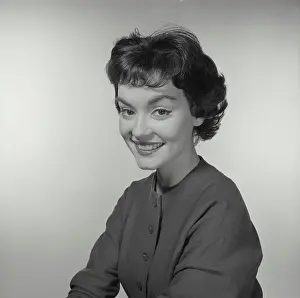 Vintage Photograph. Woman looks to the left while she smiles at the camera