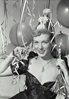 Gorgeous Prints: Vintage photograph. Woman in party hat holding party blower in party scene