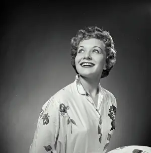 Poses Prints: Vintage Photograph. Woman poses for studio portrait she looks to the top left of frame and smiles big