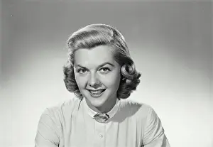 Wears Prints: Vintage Photograph. Woman smiles and wears a white shirt on a white background in studio portrait