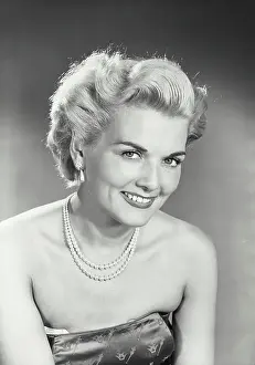 Vintage photograph. Woman in strapless dress smiling at camera
