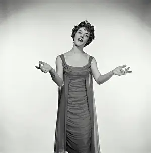 Singing Prints: Vintage Photograph. Woman in studio portrait has her hands up to her sides while she sings