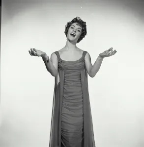 Singing Prints: Vintage Photograph. Woman in studio portrait sings while she has her hands with palms up to her sides