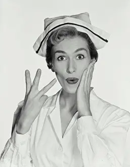 Eyebrows Prints: Vintage Photograph. Woman wearing nurse uniform holding up three fingers on right hand