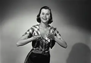 Raised Prints: Vintage Photograph. Woman wears silky striped shirt while having her hands raised she smiles in studio portrait