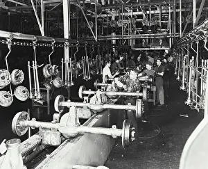 Cars Prints: Vintage photograph. Workmen attach a steering assembly to an auto chassis
