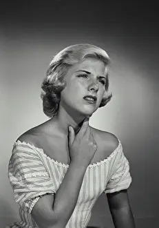 Discomfort Prints: Vintage Photograph. Young blonde woman wearing striped blouse holding throat in discomfort