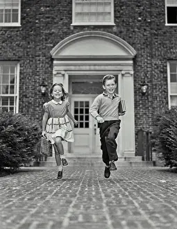 Walkway Prints: Vintage Photograph. Young boy and girl walking down path with school supplies. Frame 8