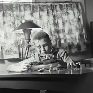 Focused Prints: Vintage Photograph. young boy sitting at desk working on building model ship