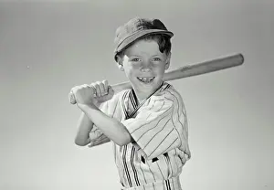 Uniform Prints: Vintage Photograph. Young boy wearing baseball uniform holding bat over shoulder