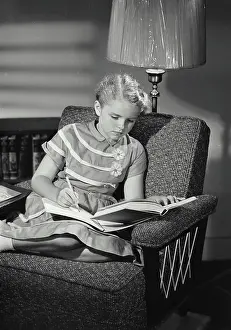 School Girl Prints: Vintage Photograph. Young girl in dress sitting in chair doing homework