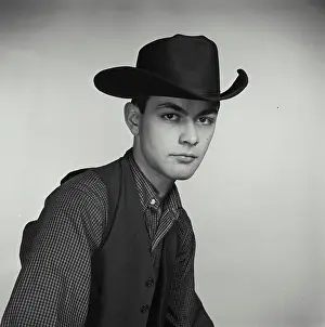 Johnson Prints: Vintage Photograph. Young man poses for studio portrait wearing cowboy hat and vest
