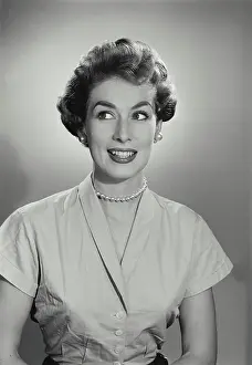 Vintage Photograph. Young woman cringes while she looks to the left of frame