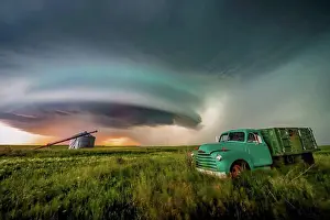 Farm Prints: Vintage truck on farmland under a dramatic stormy sky; Moose Jaw, Saskatchewan, Canada