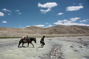Afghan Prints: A Wakhi man from the Wakhan Corridor of Afghanistan crossing a river