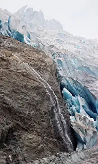 Global Warming Prints: A waterfall flows down bedrock on the edge of Mendenhall Glacier