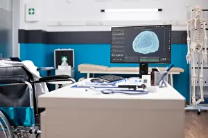 Keyboard Prints: Wheelchair user doctors table with desktop pc showing brain imaging in vacant clinic room