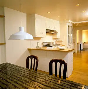 Dining Rooms Prints: White pendant light above ridged metal table in modern white kitchen