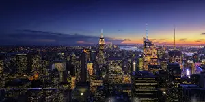 Destination Prints: Wide angle drone view of illuminated skyscrapers located in downtown of modern city against cloudy sundown sky