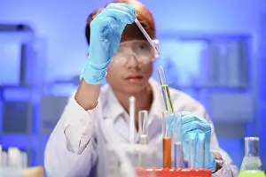 Innovation Prints: Wissenschaftler, die im Labor arbeiten und mit einer Pipette eine flüssige Probe in ein Reagenzglas tropfen
