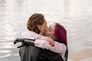 Handicapped Prints: Woman with amputated hand kissing boyfriend on cheek by river