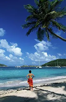 Woman on a beach with palm trees on Peter Island, British Virgin Islands, Caribbean, North America