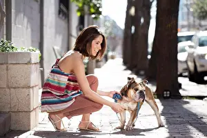 Companion Prints: Woman bent down next to her English Bull Dog while holding it on a leash
