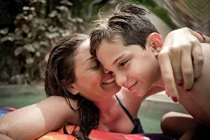 Quality Time Prints: A woman and a boy cuddling in a swimming pool