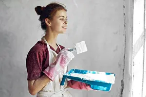 Paintbrush Prints: woman with brush in hands paint inside home interior renovation