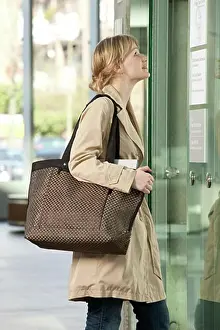 Business Women Prints: Woman Carrying Handbag Looking at Directory