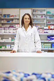 Desk Prints: Woman, counter and happy as pharmacist at drug store with pride for customer service