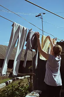 Fourties Prints: Woman dries clothes on clothesline on sunny day
