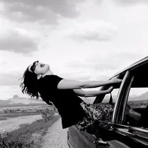Above 18 Prints: A woman hanging out a moving car window