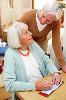 Converse Prints: Woman helping elderly woman doing paperwork