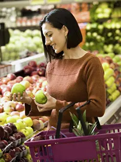 Produce Prints: Woman holding green apples at grocery store with shopping basket