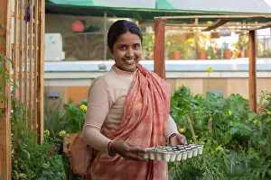 Sowing Prints: A woman holding seedling tray in her kitchen garden