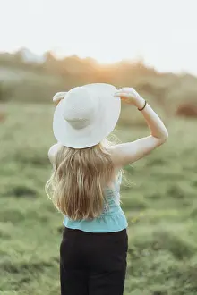 Traveller Prints: woman in jacket and hat enjoys the sunset alone