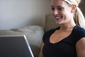Consumer Electronics Prints: Woman on a laptop looking at a business card