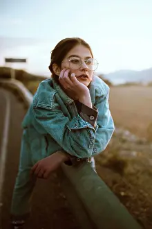Denim Prints: Woman leaning on fence on road