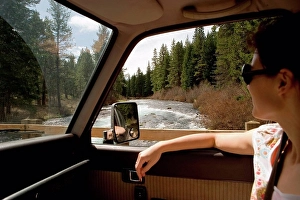 Only One Prints: Woman looking through car window at forest scenery