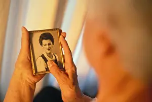 Senior Adult Prints: Woman looking at old photograph