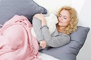 Leisure Wear Prints: Woman lying on couch with hot water bottle